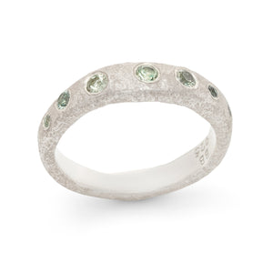 
            
                Load image into Gallery viewer, Angled view of Narrow Molten Band in Sterling Silver with green sapphires by Betsy Barron
            
        